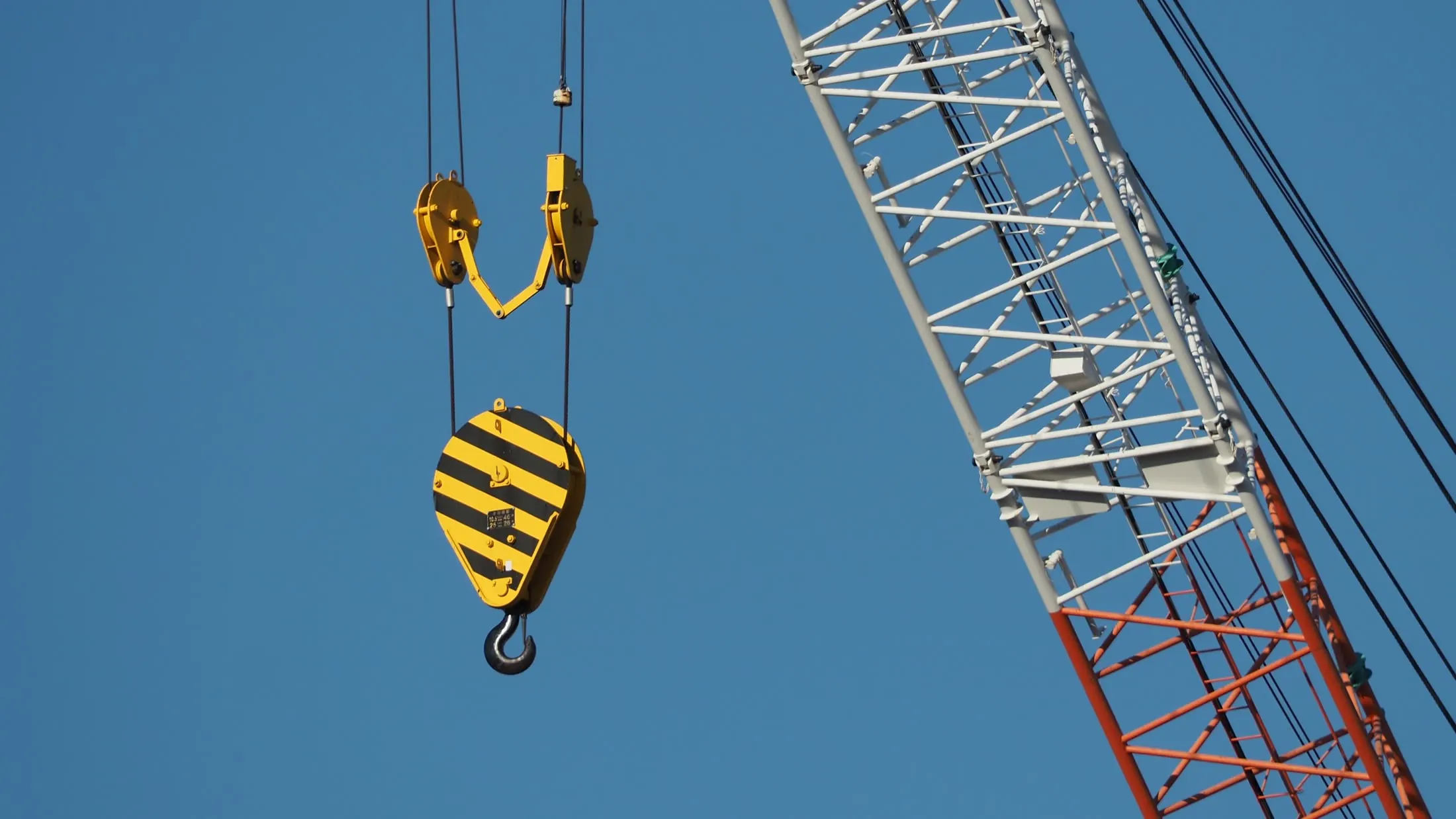Crane hook block hanging beside a lattice crane boom